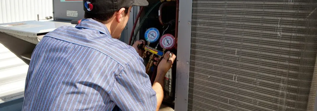 HVAC technician servicing a condenser unit in Atlantic Beach